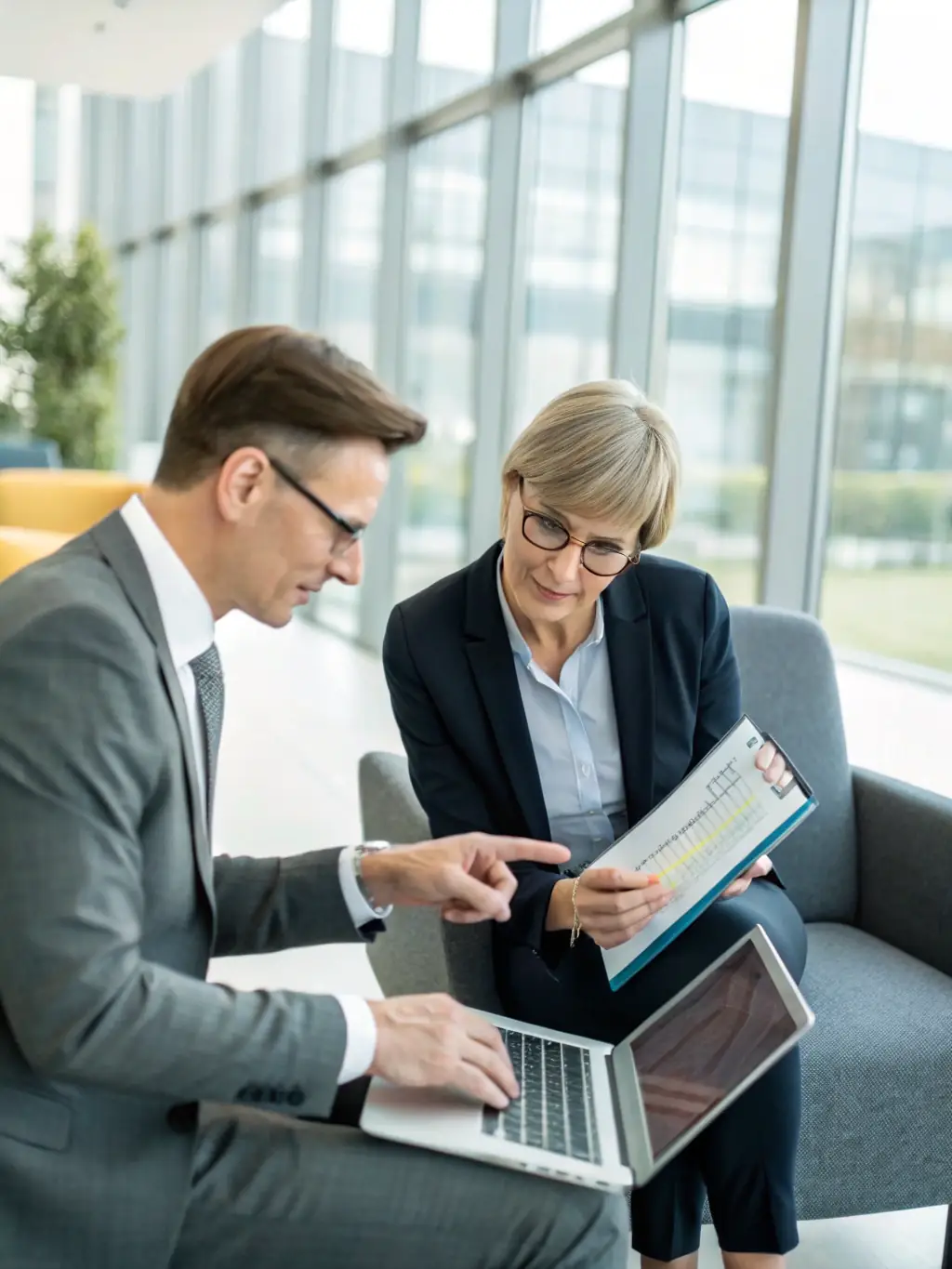 A professional business consultant in a suit reviewing a security risk assessment report with a client in a modern office, emphasizing strategic business protection.