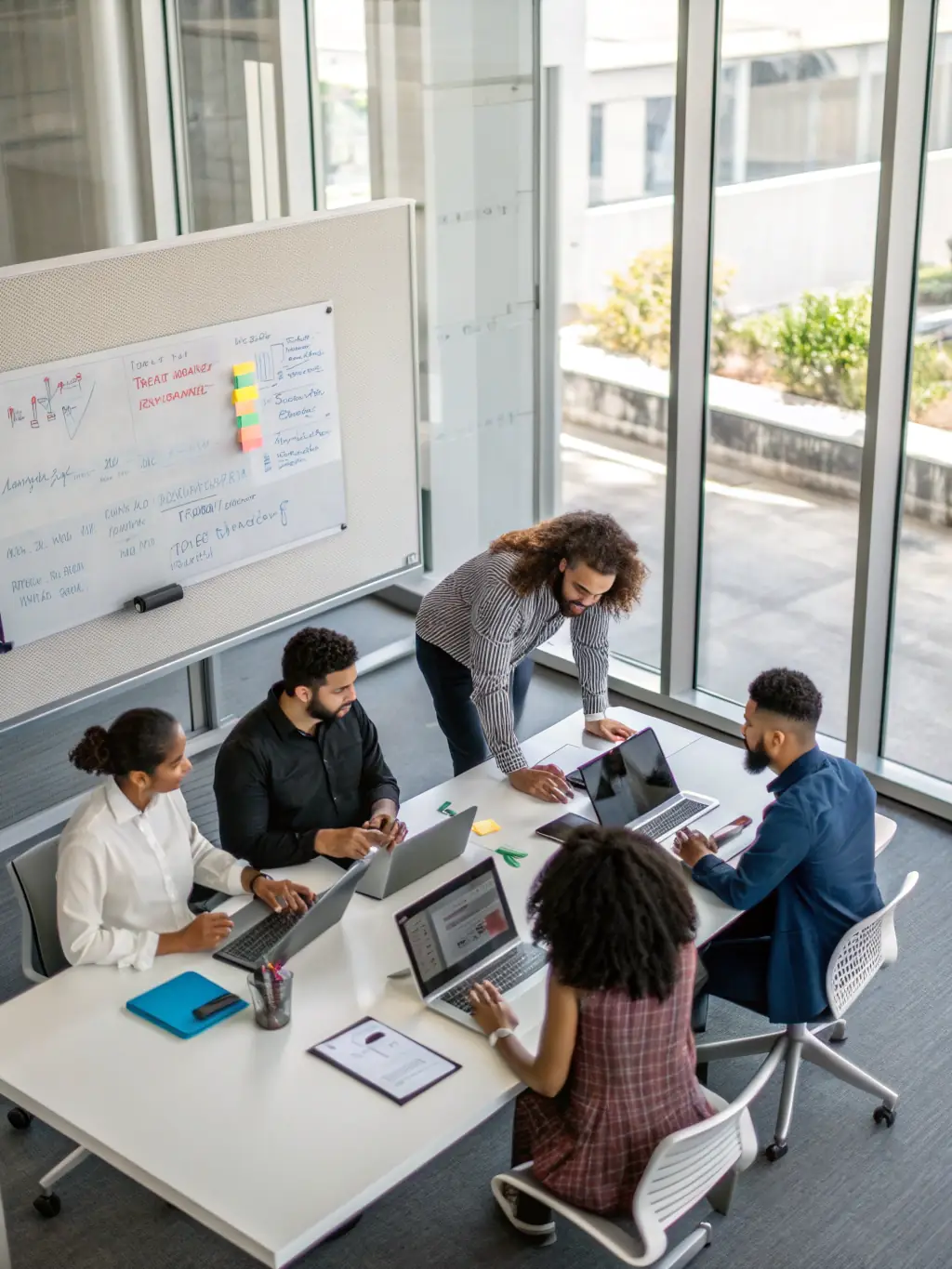 A diverse team collaborating over laptops and digital devices, with network diagrams and cloud icons in the background, illustrating technology integration and business connectivity.